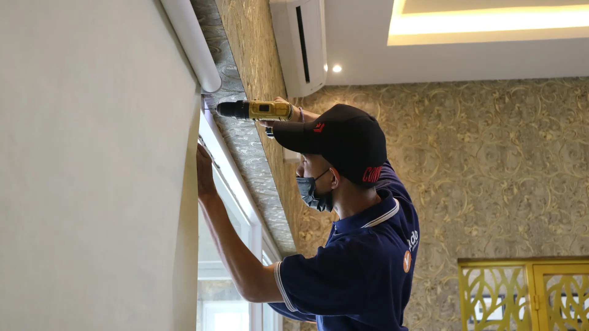 Profissional instalando persiana em janela de ambiente residencial