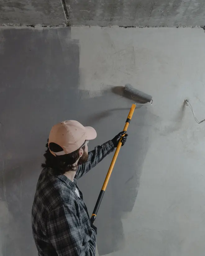 Profissional pintando parede interna com rolo