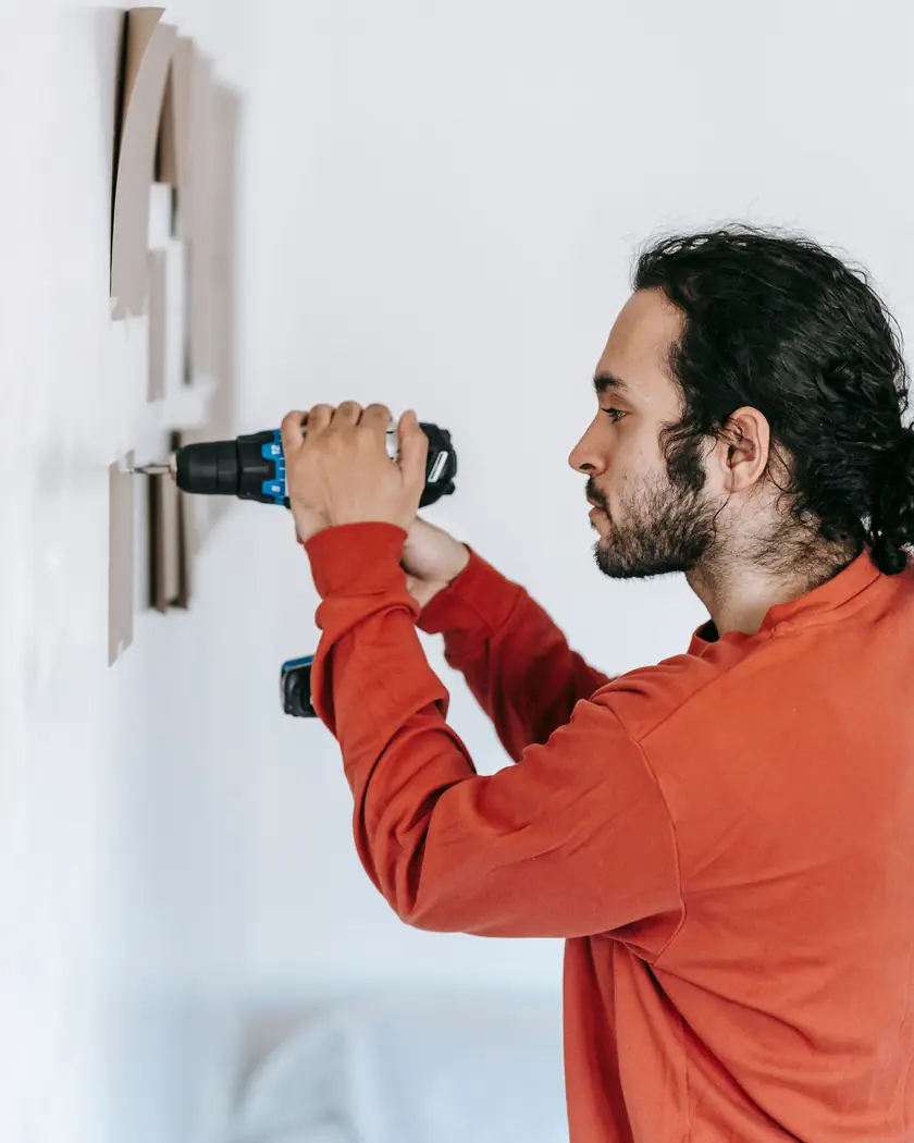 Profissional furando parede com parafusadeira para instalação
